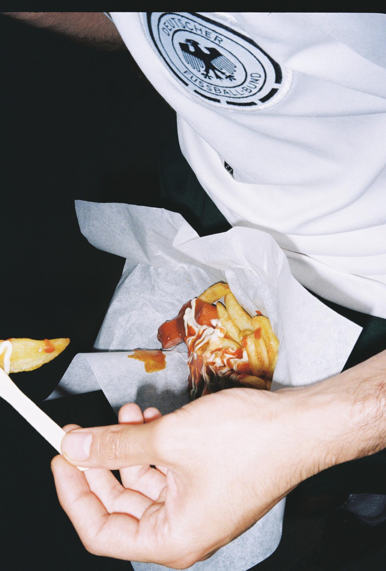 pommes mit ketchup in der hand